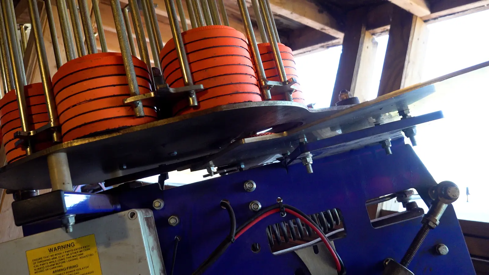 Clay target machines loaded with orange clays inside the bunker